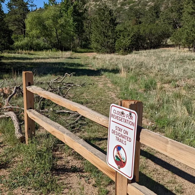 Closed for revegetation sign asking visitors to stay on designated trails